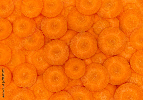 Carrot slices background. Background of raw carrot texture. Close-up fresh carrots for sliced vegetables, cut, cooking, round pieces, and fresh ingredients. Abstract orange background of vegetables.