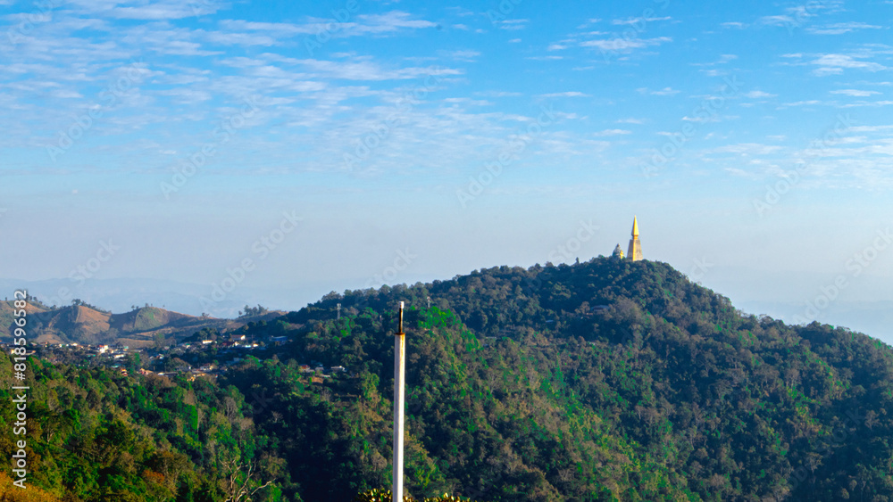 central focus is a majestic mountain, lush with greenery, rising against a clear blue sky adorned with scattered white clouds. central focus is a majestic mountain, lush with greenery, rising against a clear blue sky adorned with scattered white clouds.