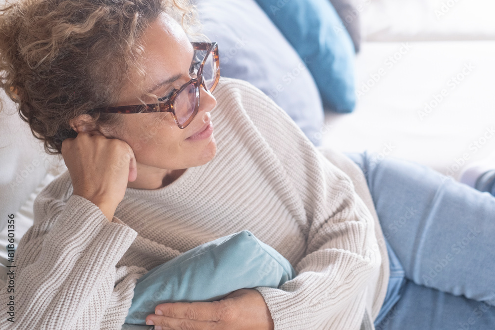 One lady having relax indoor leisure activity laying on sofa in chilling moment smiling and looking ahead. Female people enjoying cozy home and relaxation time alone in living room. Bright image One lady having relax indoor leisure activity laying on sofa in chilling moment smiling and looking ahead. Female people enjoying cozy home and relaxation time alone in living room. Bright image