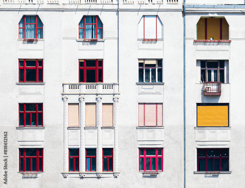Facade of a building with red window frames of different shapes
