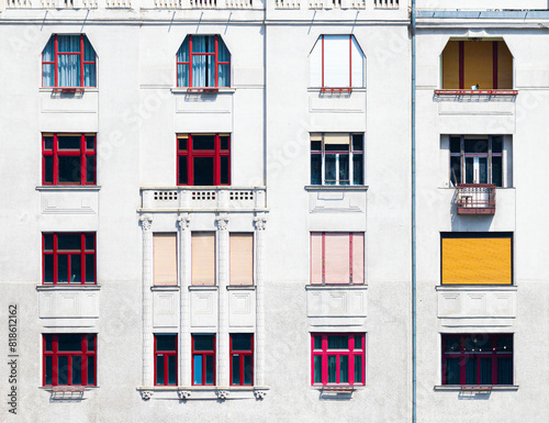 Obraz na płótnie Facade of a building with red window frames of different shapes w salonie