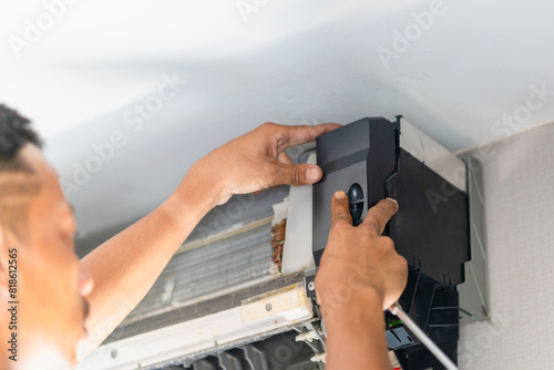 Technician checked dirty air conditioning control board, Repairman fixed air conditioning systems, Technician man service repair and maintenance of air conditioners. photo