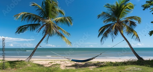 A serene beach scene with palm trees swaying gently in the breeze and a hammock hanging between two of them © LaxmiOwl