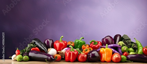 The copy space image depicts a vegetarian concept with a background consisting of organic peppers and eggplants photo