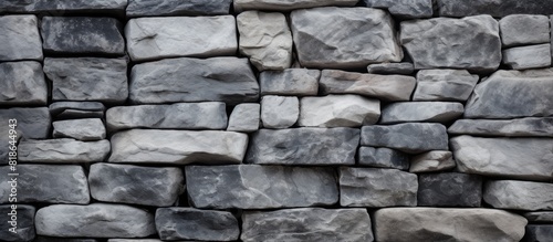 A textured uneven gray stone wall serves as the backdrop for a simple rock blocks background The image contains copy space