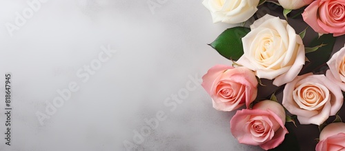 A flat lay view of a pink and white rose flower composition on a pastel gray background with plenty of copy space for text or other elements