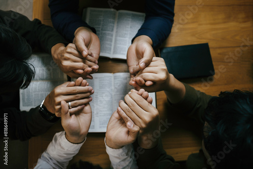 Christian Family prayer and worship. Christian group of people holding hands and praying worships to believe and Bible on a wooden table prayer meeting concept. Church Community pray together