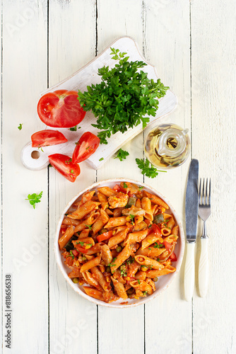 Classic italian pasta penne arrabbiata with vegetables on white wooden table. Penne pasta with sauce arrabbiata. Top view, overhead