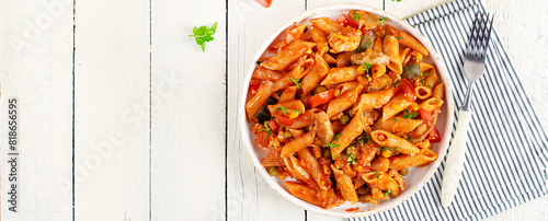 Classic italian pasta penne arrabbiata with vegetables on white wooden table. Penne pasta with sauce arrabbiata. Top view, banner