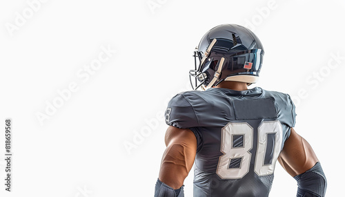 American football player in a black helmet and uniform stands with his back. White background. Copy space © Semper Fidelis