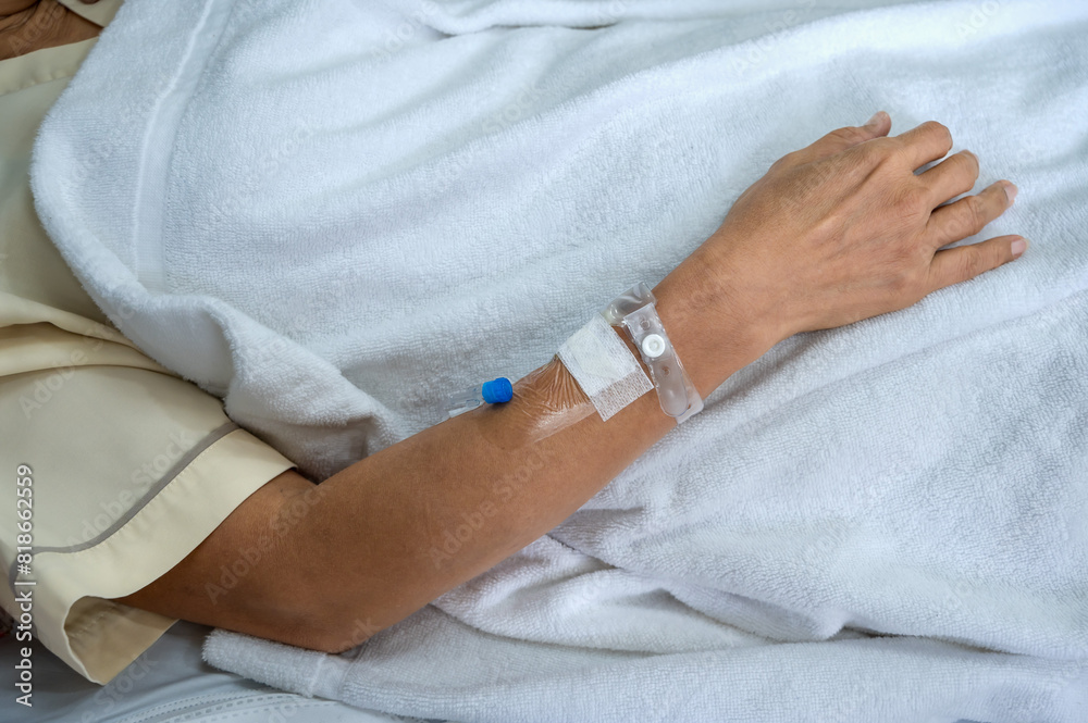 Close up patient arm with iv needle and bandage for medical care in hospital
