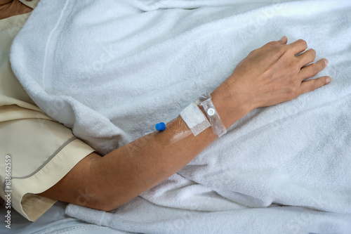Close up patient arm with iv needle and bandage for medical care in hospital