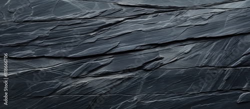 High resolution top view of a naturally patterned background made of black slate stone The image provides ample copy space
