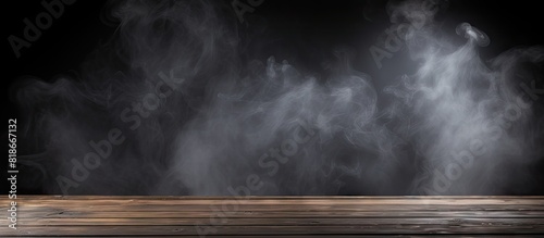 A dark background highlights an empty wooden table where smoke elegantly rises The perfect copy space image to showcase your products