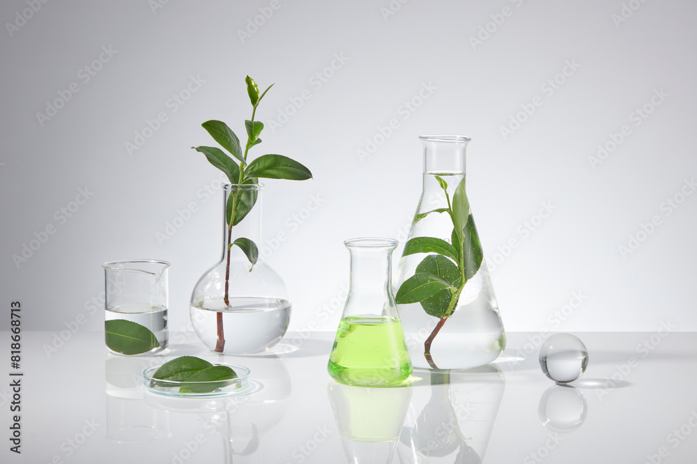 Plenty experiment instruments displayed on white table top over white background with green tea ingredient decoration, blank space for adding text and elements of designing
