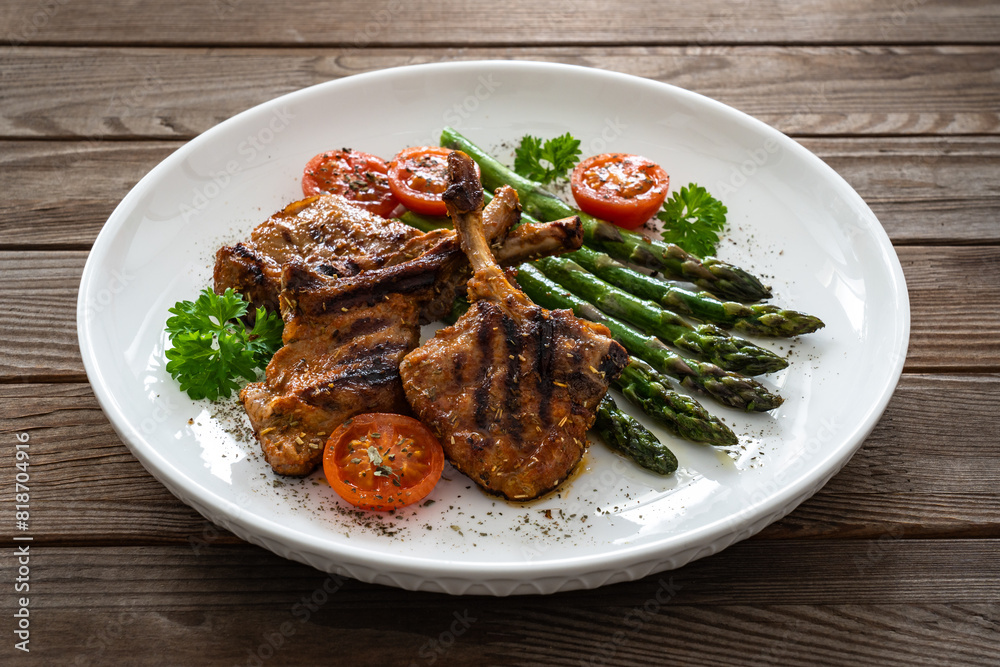 Lamb chops with bone and cooked green asparagus on wooden table
Lamb chops with bone and cooked green asparagus on wooden table