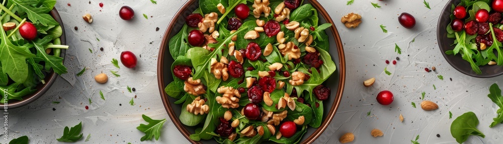 An overhead view showcases a colorful salad topped with nuts and cranberries on a bright white backdrop An overhead view showcases a colorful salad topped with nuts and cranberries on a bright white backdrop