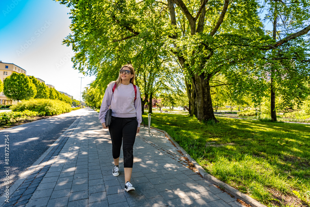 Spring walk - mid-adult beautiful woman walking in city park on sunny day
Spring walk - mid-adult beautiful woman walking in city park on sunny day