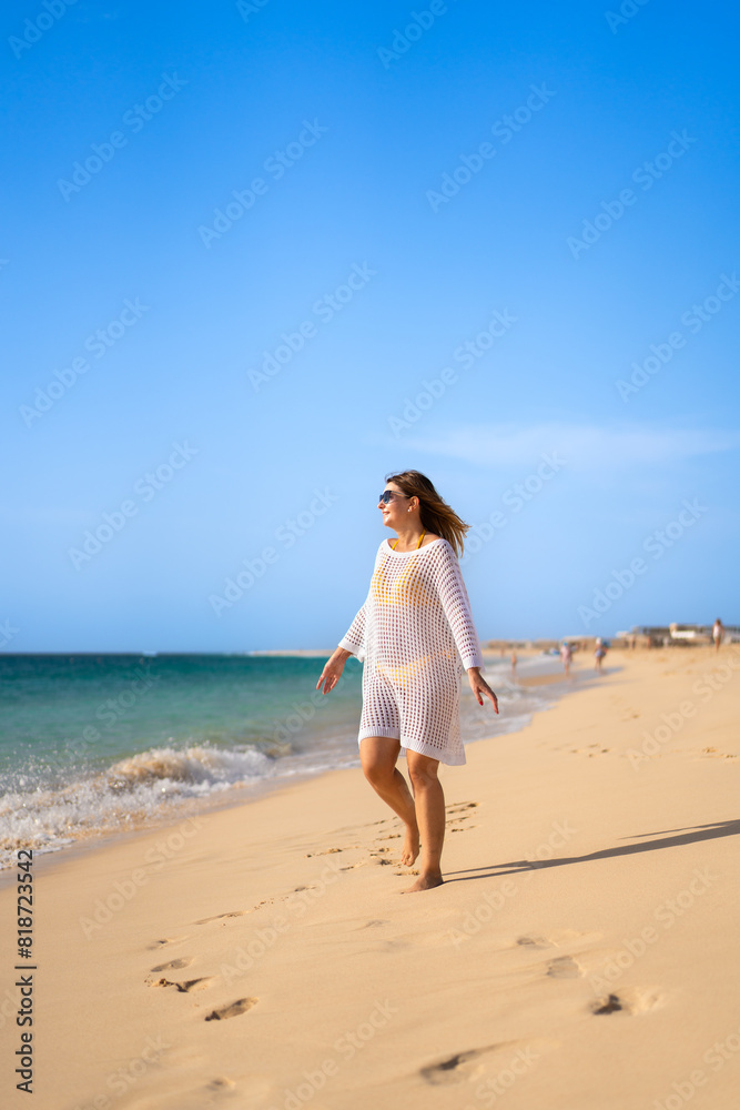 Beautiful woman walking on sunny beach Beautiful woman walking on sunny beach