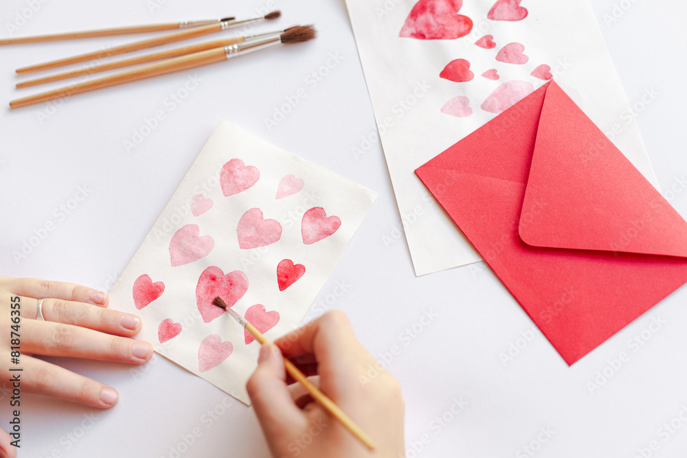 Closeup of a person crafting paper hearts with pencils on an envelope for Valentine's day Closeup of a person crafting paper hearts with pencils on an envelope for Valentine's day