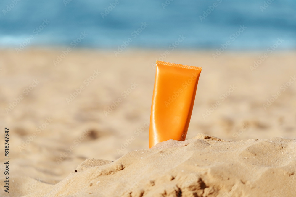 orange sunscreen bottle on sandy beach orange sunscreen bottle on sandy beach