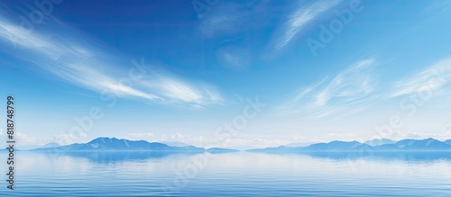 A serene scene with a clear blue sky mirrored in a calm blue ocean creating a captivating copy space image © HN Works