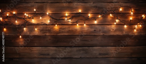 A festive display of Christmas lights adorning a rustic wooden background offering ample copy space for images