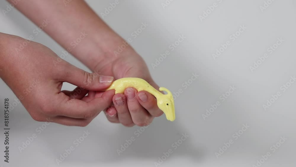 Squishing a Yellow Dinosaur Toy
