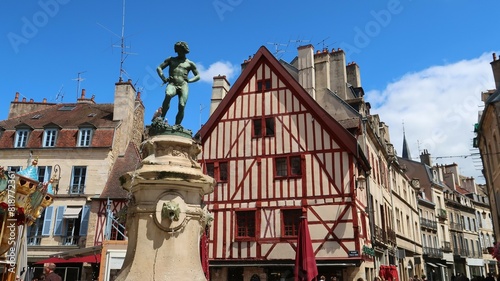 Place François Rude, dite place du Bareuzai, dans la ville de Dijon, en Côte d’Or / Bourgogne, avec la statue fontaine du Vendangeur et une maison à colombages à l’entrée de la rue des Forges (France)