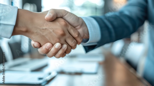 Image shows a close-up of a handshake between two individuals, symbolizing a deal or agreement