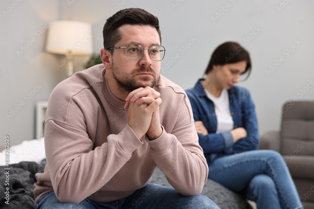 Offended couple ignoring each other after quarrel in bedroom, selective focus. Relationship problems Offended couple ignoring each other after quarrel in bedroom, selective focus. Relationship problems