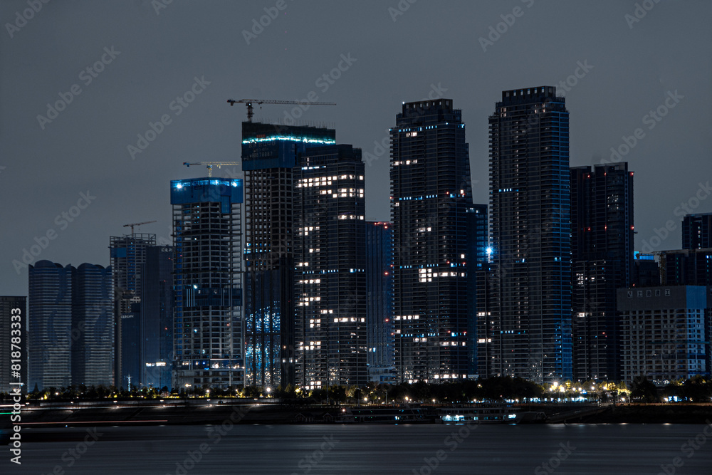 Fototapeta premium City skyline at night with tall buildings near the ocean in Wuhan, China