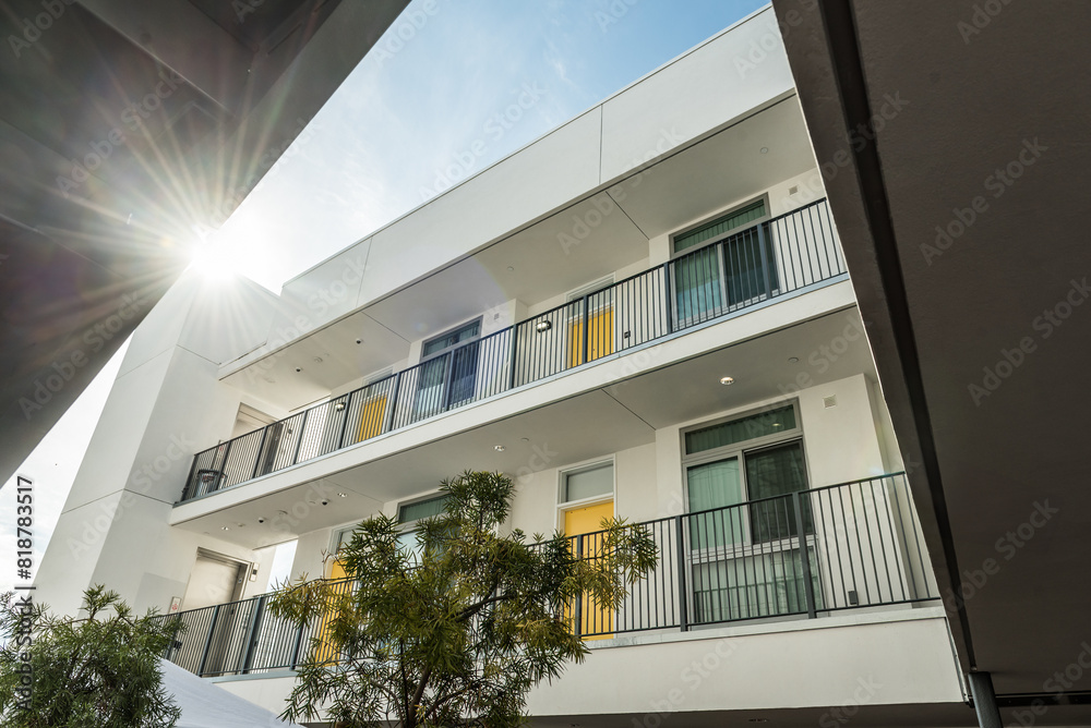 Fototapeta premium Sun peaking through an apartment building on a sunny afternoonsunny
