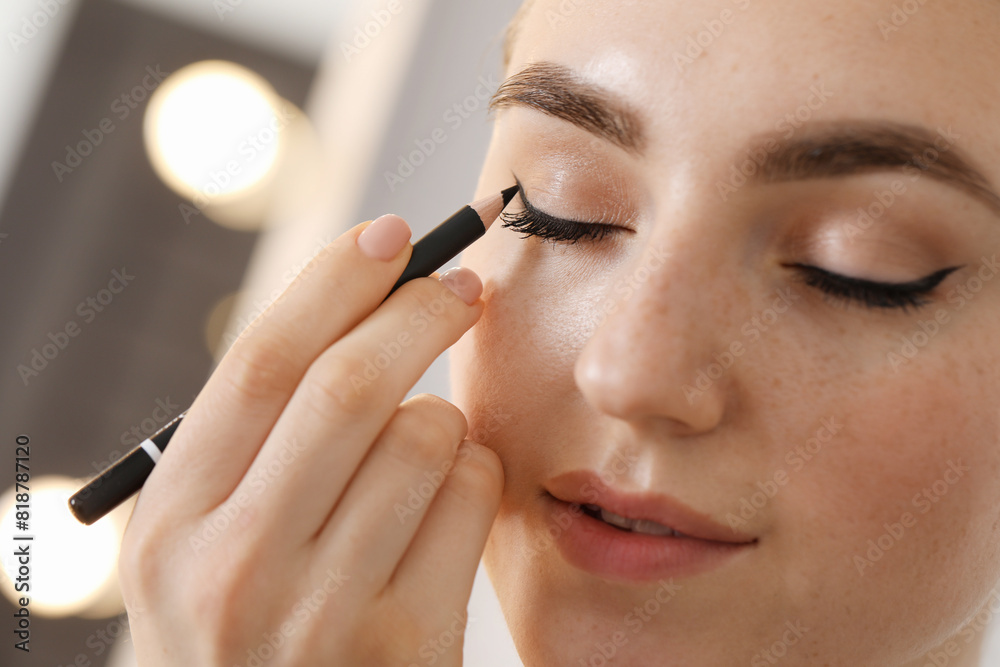Makeup product. Woman applying black eyeliner indoors, closeup Makeup product. Woman applying black eyeliner indoors, closeup