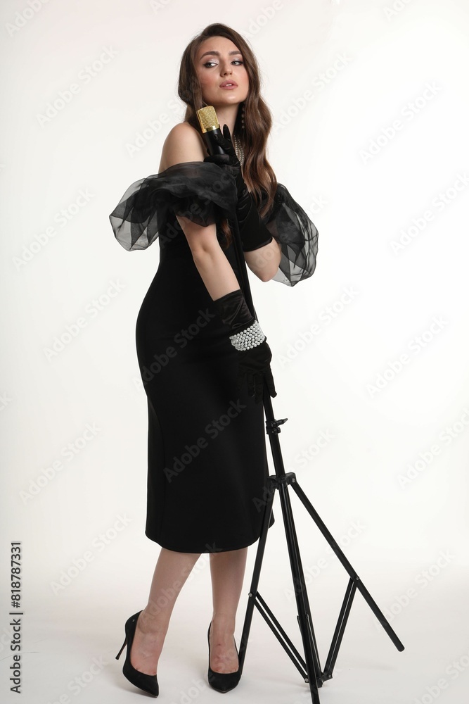 Beautiful young woman in stylish dress with microphone singing on white background Beautiful young woman in stylish dress with microphone singing on white background