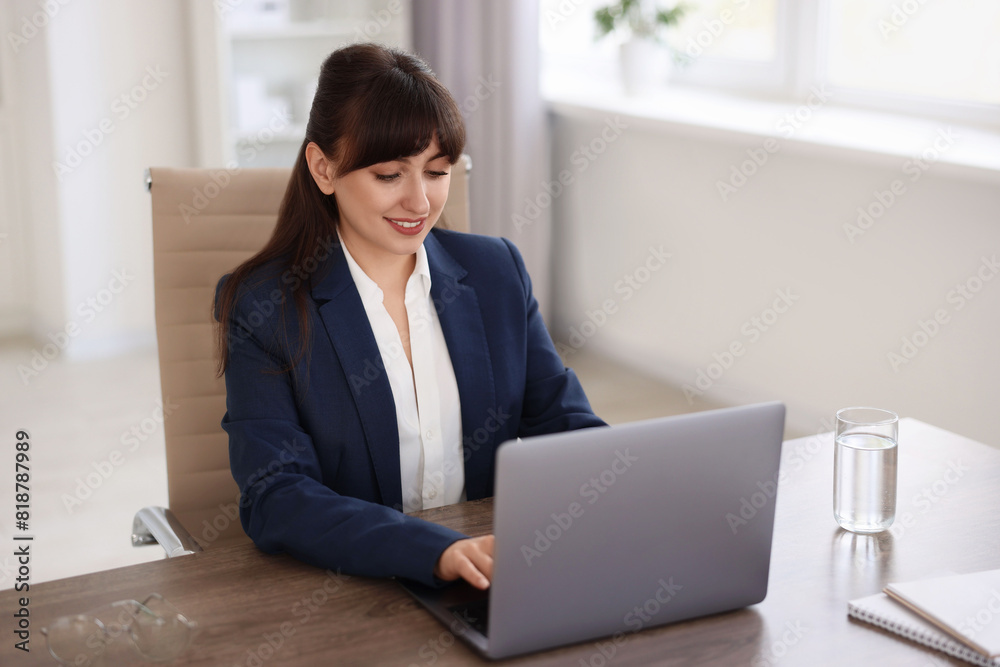 Woman watching webinar at wooden table in office Woman watching webinar at wooden table in office