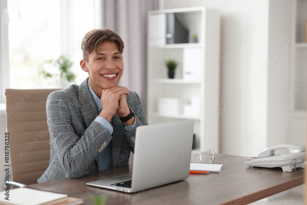 Man watching webinar at wooden table in office Man watching webinar at wooden table in office
