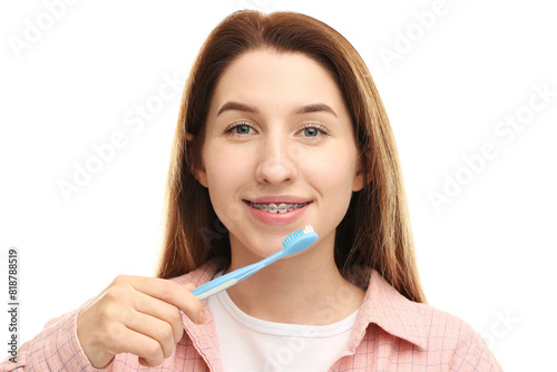Smiling woman with dental braces cleaning teeth on white background