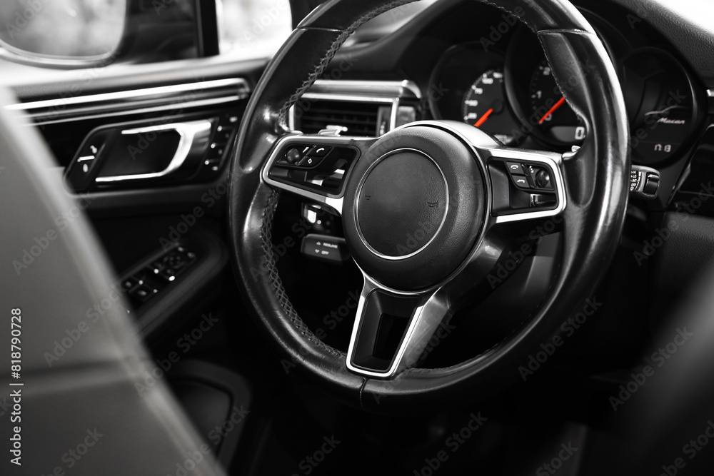 Steering wheel inside of modern black car, closeup