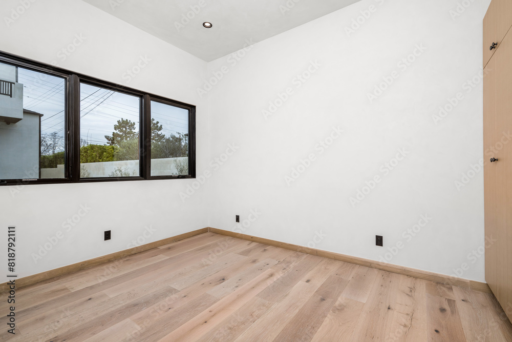Fototapeta premium a white empty room with a window and wood floors in it