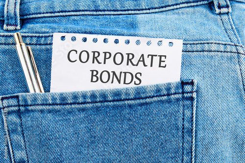 Finance and economics concept. CORPORATE BONDS written on a piece of paper that appeared from the pocket of jeans