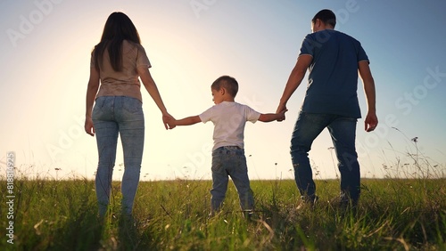 family walking park together. The family silhouette walking on the sunset is a stunning representation of the beauty of nature. happy family kid dream concept lifestyle