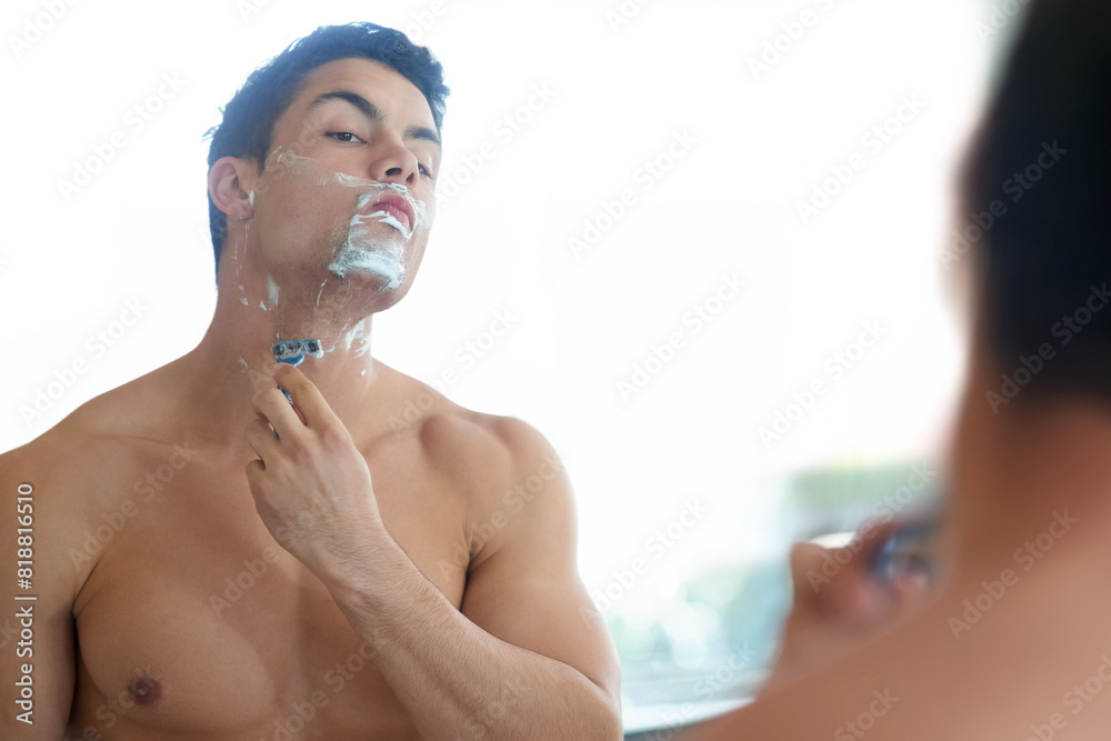 Man, bathroom and shaving beard in mirror with razor for hygiene and fresh skin with hair removal. Skin care, grooming and home with cream or soap for facial hair for wellness, self care and routine