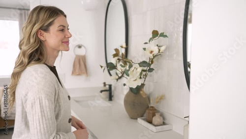 Caucasian female model drying her hands with towel and then fixing her hair in mirror