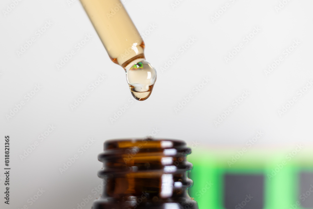 Close-Up Of Dropper With Liquid Over Brown Bottle. A close-up image showcasing a dropper releasing a droplet of liquid into a brown glass bottle. Close-Up Of Dropper With Liquid Over Brown Bottle. A close-up image showcasing a dropper releasing a droplet of liquid into a brown glass bottle.