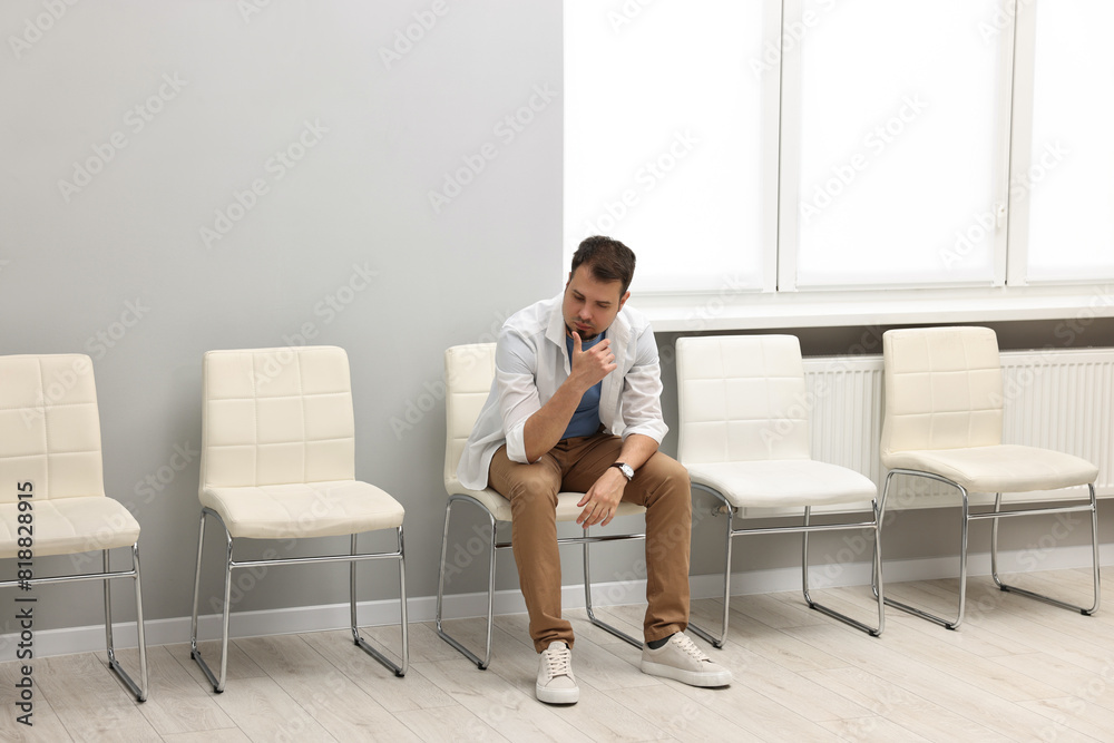 Man sitting on chair and waiting for appointment indoors Man sitting on chair and waiting for appointment indoors