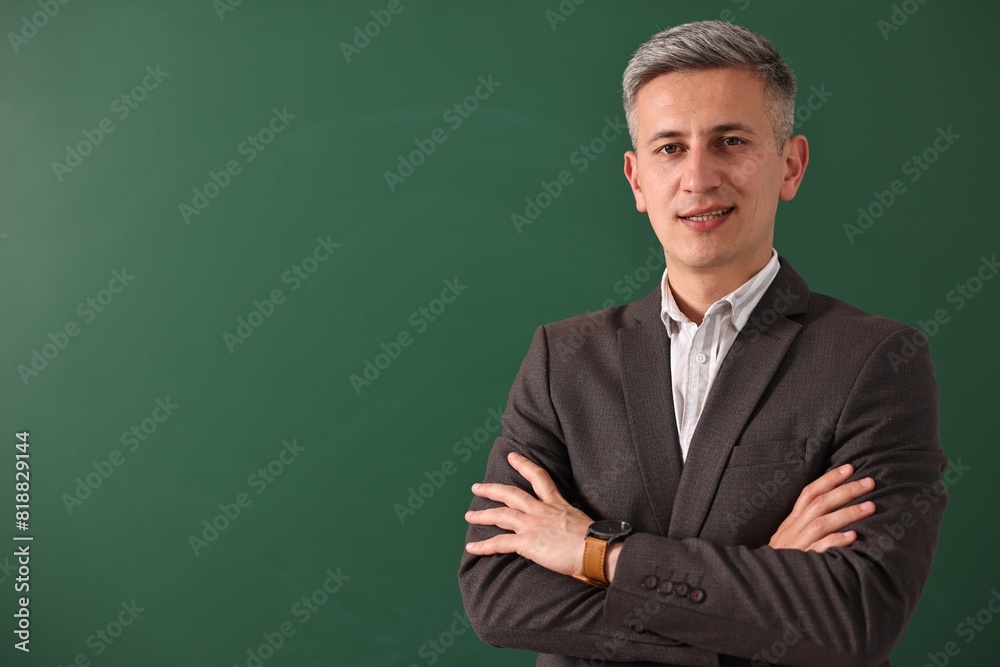 Teacher with crossed arms near chalkboard, space for text Teacher with crossed arms near chalkboard, space for text