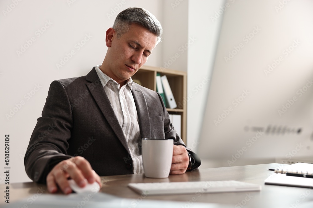 Man with cup of drink snoozing at table in office Man with cup of drink snoozing at table in office
