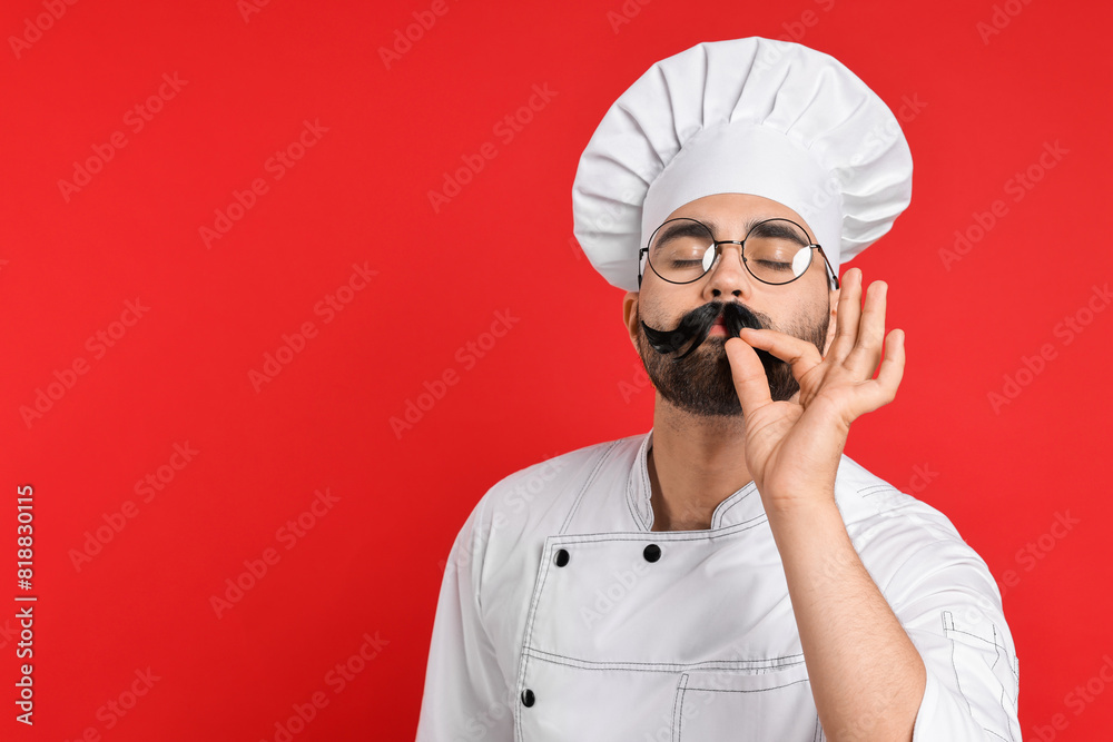 Professional chef with funny artificial moustache showing perfect sign on red background. Space for text Professional chef with funny artificial moustache showing perfect sign on red background. Space for text