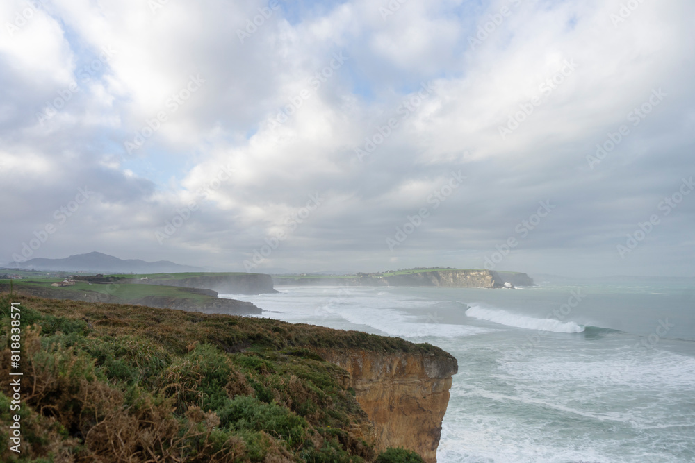 Landscape of cliffs and raging sea in the middle of nature with the sky overcast in Cantabria. Spain Landscape of cliffs and raging sea in the middle of nature with the sky overcast in Cantabria. Spain